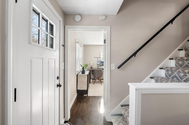 entryway with stairs, baseboards, and dark wood-type flooring