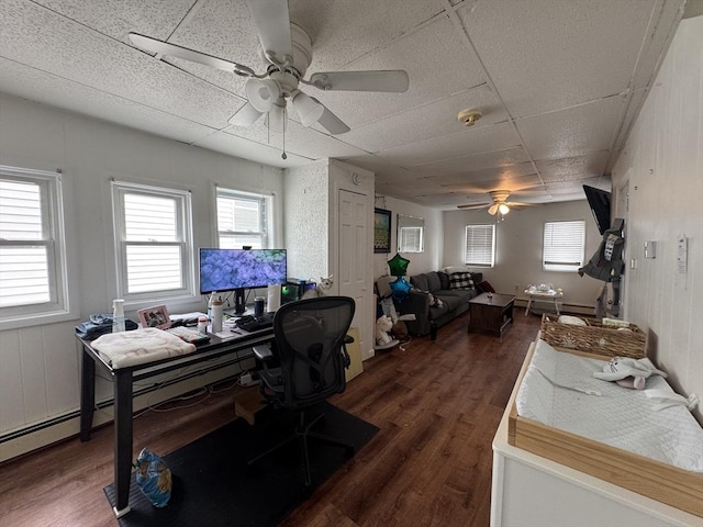 office area featuring dark wood-type flooring, ceiling fan, and a healthy amount of sunlight