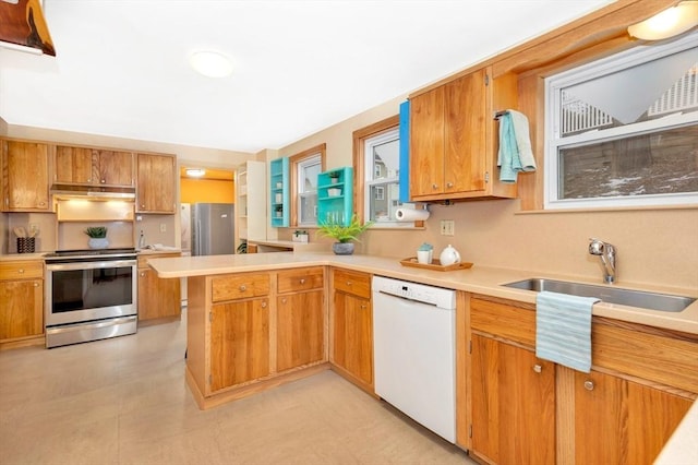 kitchen with appliances with stainless steel finishes, sink, and kitchen peninsula