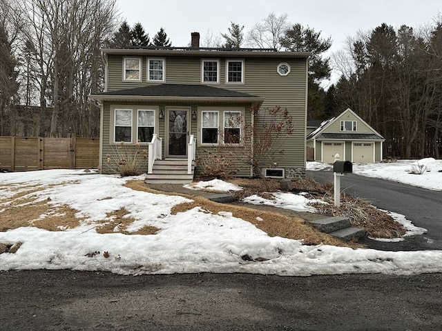 view of front of property featuring a garage, an outdoor structure, fence, a gate, and a chimney