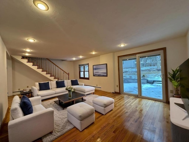 living room featuring stairs, a baseboard heating unit, wood finished floors, and recessed lighting