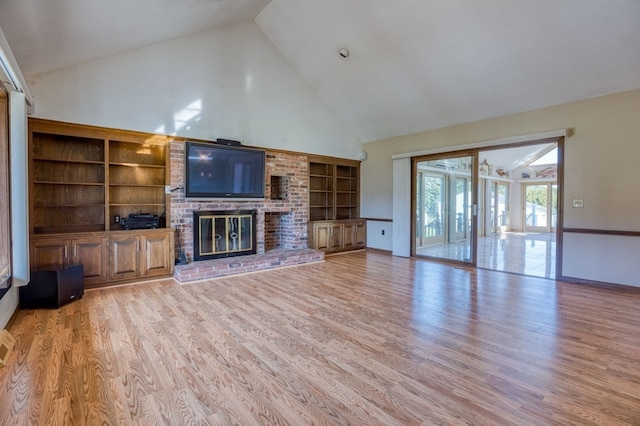 unfurnished living room with a brick fireplace, built in features, high vaulted ceiling, and light wood-type flooring