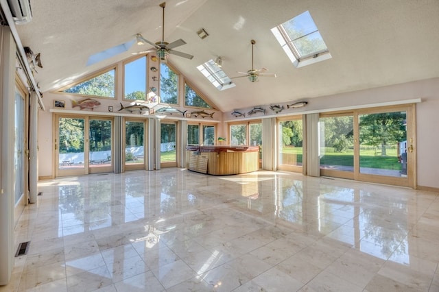 unfurnished sunroom featuring ceiling fan and vaulted ceiling with skylight