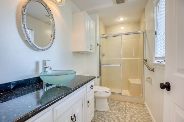 bathroom with tile patterned floors, vanity, toilet, and a shower with shower door