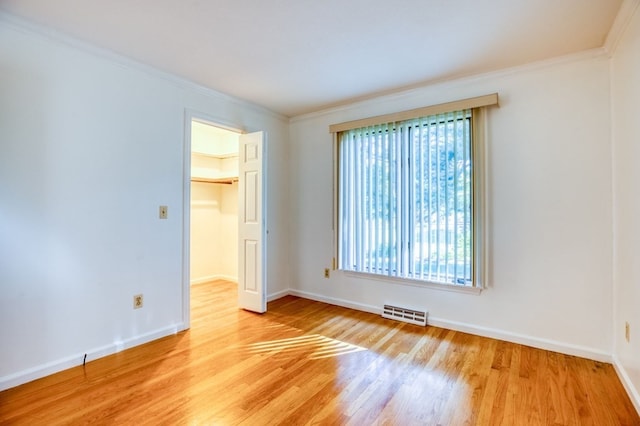 empty room featuring light hardwood / wood-style flooring and crown molding