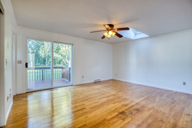 unfurnished room featuring a skylight, ceiling fan, light hardwood / wood-style flooring, and ornamental molding