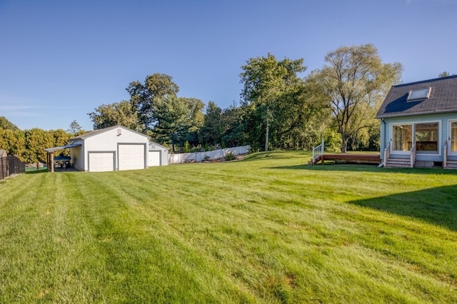 view of yard with a garage and an outbuilding