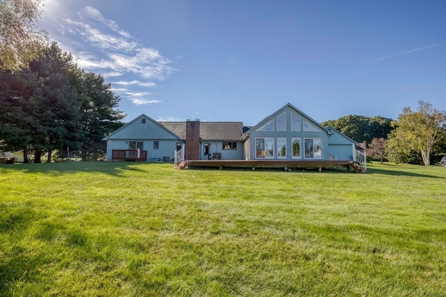 rear view of house featuring a lawn and a deck