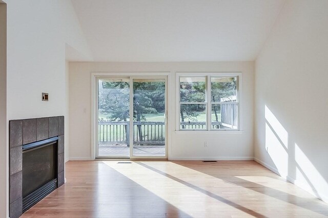11 Dillingham Way Unit 11, Plymouth, MA 02360 - unfurnished living room featuring light wood-type flooring, a tile fireplace, baseboards, and vaulted ceiling