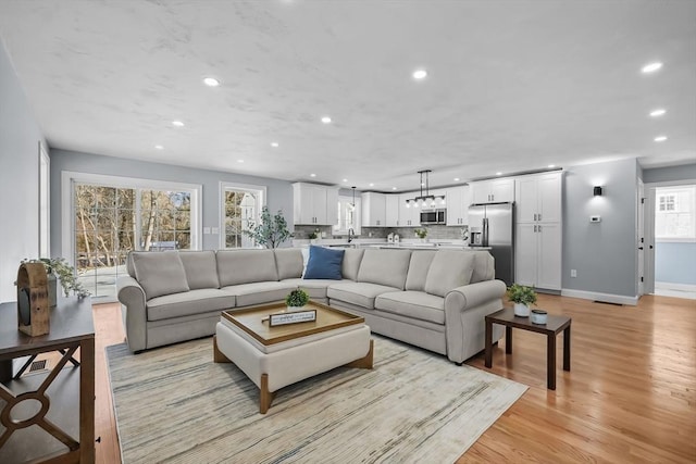 living room with light wood-type flooring and sink