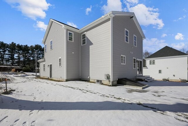 view of snow covered back of property