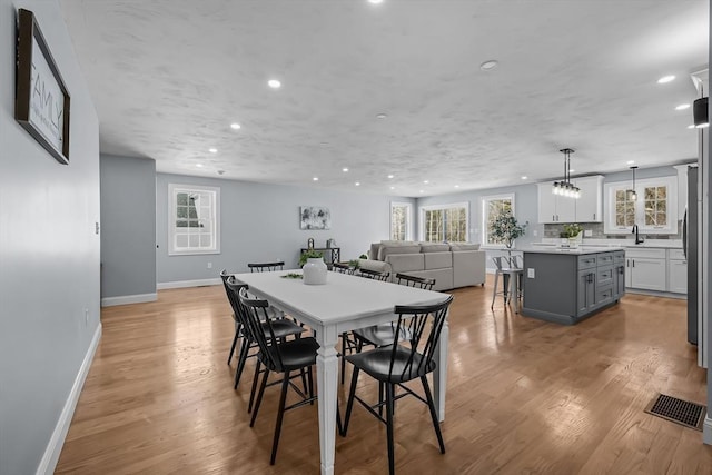 dining room featuring light wood-type flooring and sink