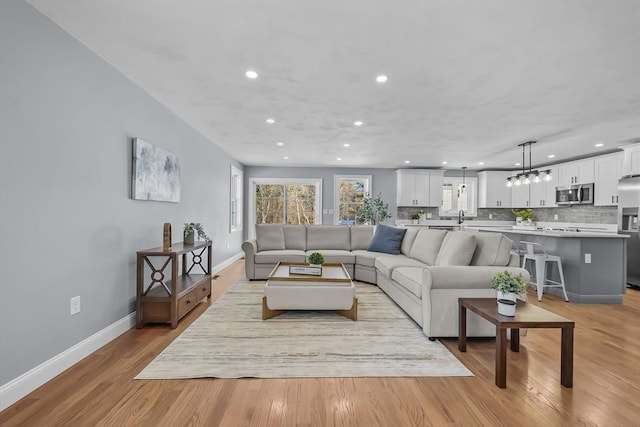 living room featuring light wood-type flooring and sink