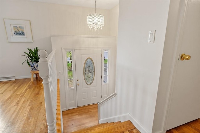 entrance foyer with light wood-style floors, a chandelier, and baseboards