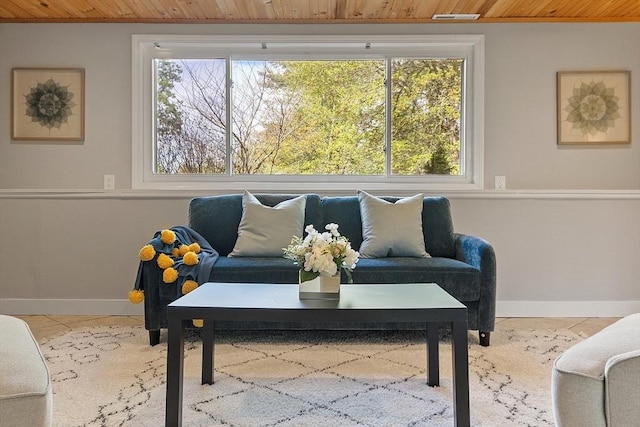 living area with wood ceiling and baseboards