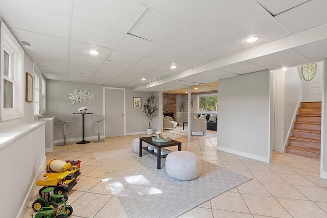 living room with light tile patterned floors, stairs, recessed lighting, baseboards, and a drop ceiling