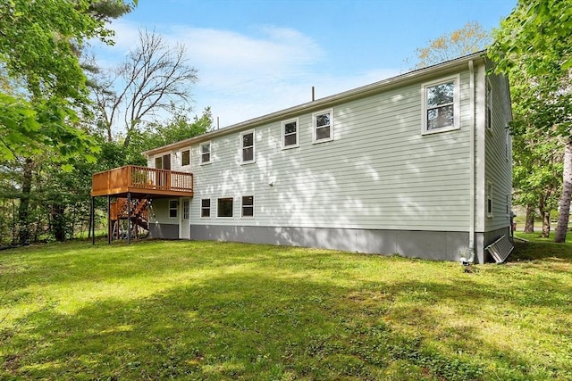 rear view of property with a deck, stairway, and a lawn
