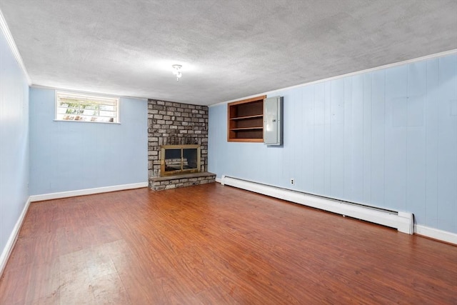 29 Gregory Rd, Wakefield, MA 01880 - unfurnished living room featuring a baseboard heating unit, wood finished floors, a large fireplace, a textured ceiling, and electric panel