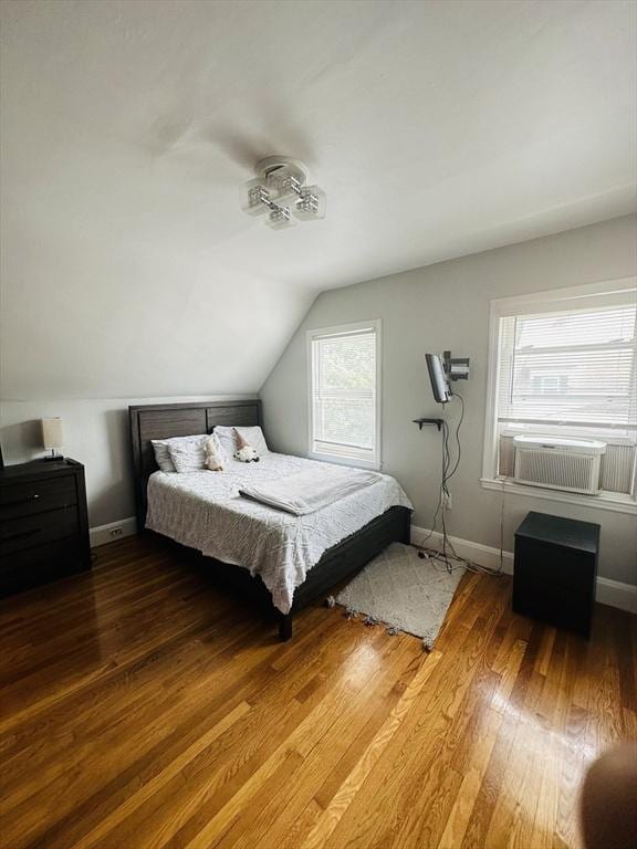 bedroom with cooling unit, lofted ceiling, and wood-type flooring