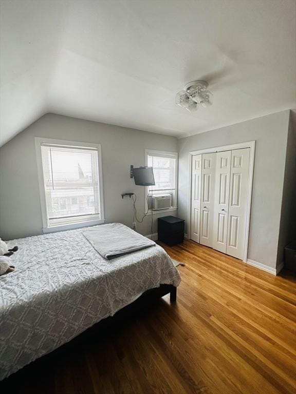 bedroom featuring hardwood / wood-style floors, a closet, and vaulted ceiling