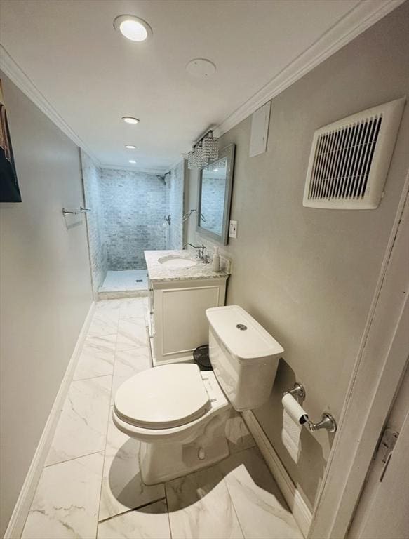 bathroom with vanity, a tile shower, crown molding, and toilet