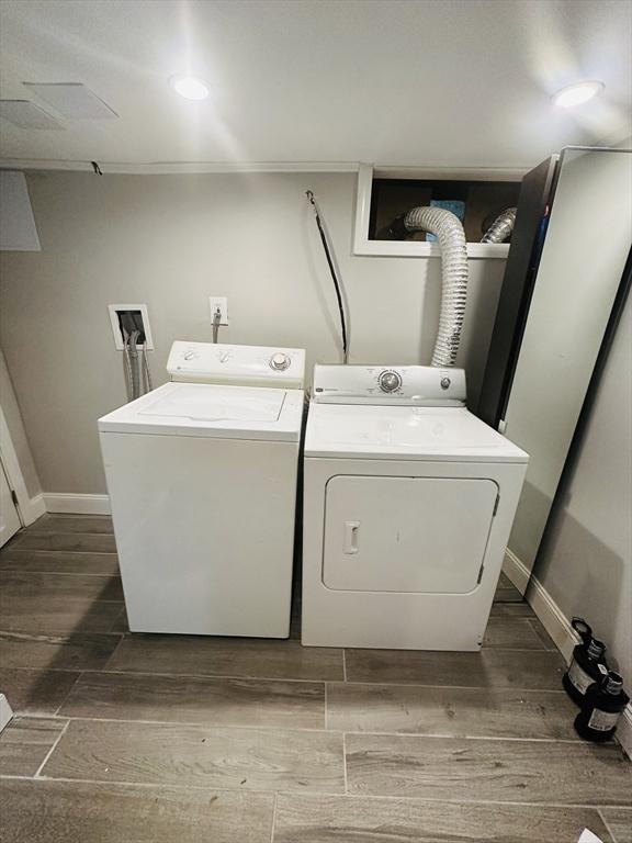 laundry room featuring independent washer and dryer and dark wood-type flooring