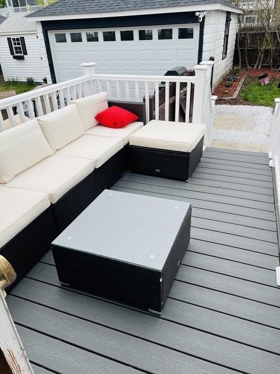 wooden deck featuring an outdoor living space and a garage