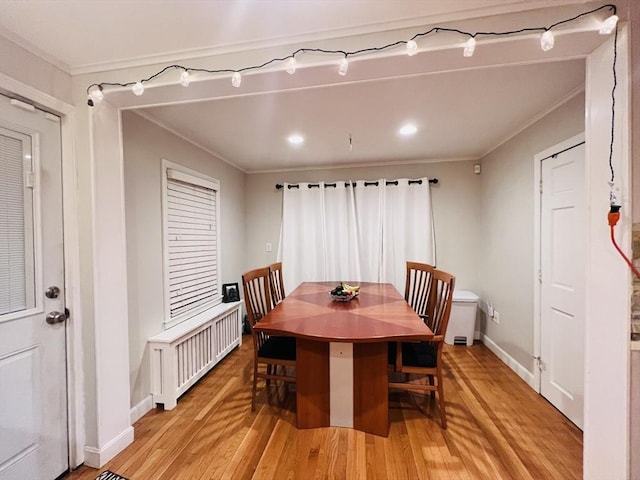 dining room with ornamental molding, light hardwood / wood-style flooring, and radiator heating unit