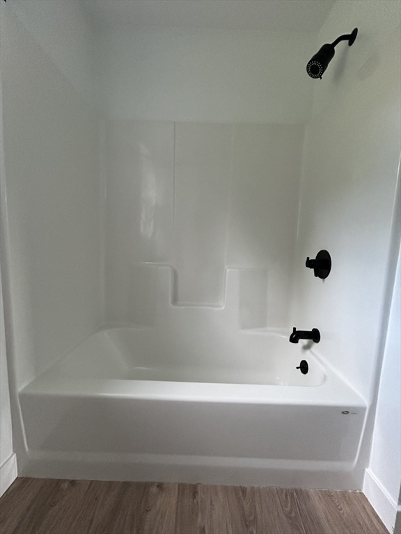 bathroom featuring wood-type flooring and tub / shower combination