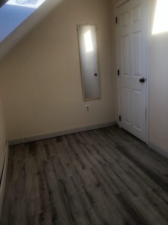 bonus room with lofted ceiling, wood finished floors, and baseboards