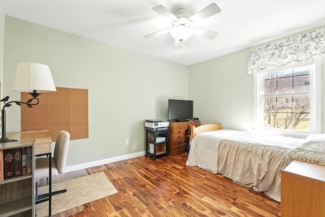 bedroom with ceiling fan, baseboards, and wood finished floors