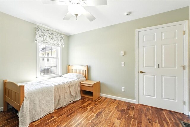 bedroom with visible vents, a ceiling fan, baseboards, and wood finished floors