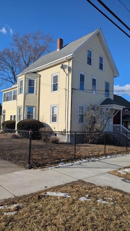 view of home's exterior featuring a fenced front yard and a chimney