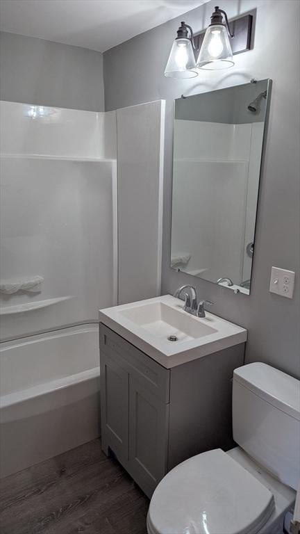 bathroom with vanity, shower / tub combination, wood finished floors, and toilet