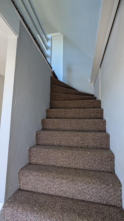 stairway featuring a textured wall