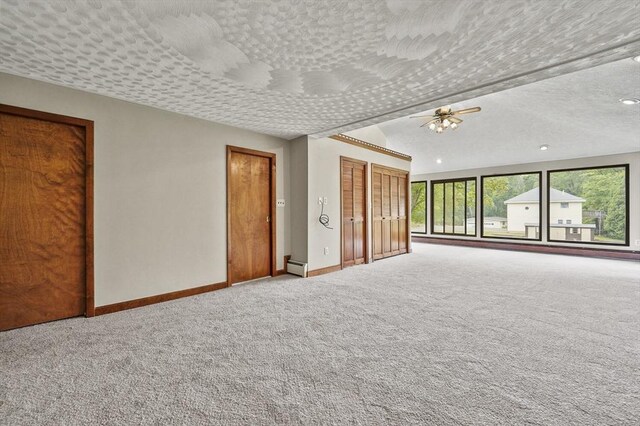 466 Hosmer St, Marlborough, MA 01752 - unfurnished bedroom with carpet, a baseboard heating unit, multiple closets, a textured ceiling, and a ceiling fan