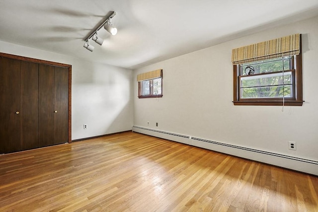 466 Hosmer St, Marlborough, MA 01752 - unfurnished bedroom with a baseboard heating unit, rail lighting, light wood finished floors, and a closet