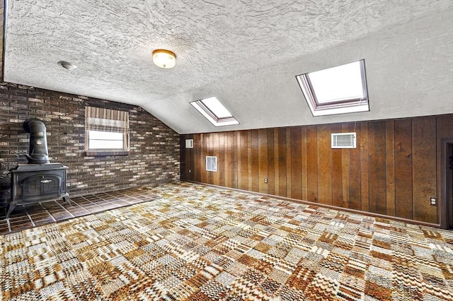 466 Hosmer St, Marlborough, MA 01752 - bonus room featuring a skylight, a wood stove, lofted ceiling, a textured ceiling, and wood walls