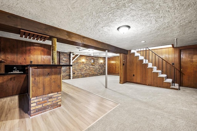 466 Hosmer St, Marlborough, MA 01752 - finished below grade area featuring brick wall, wood walls, stairway, a textured ceiling, and wood finished floors