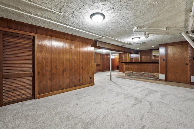 466 Hosmer St, Marlborough, MA 01752 - finished basement featuring light colored carpet, wood walls, and a textured ceiling