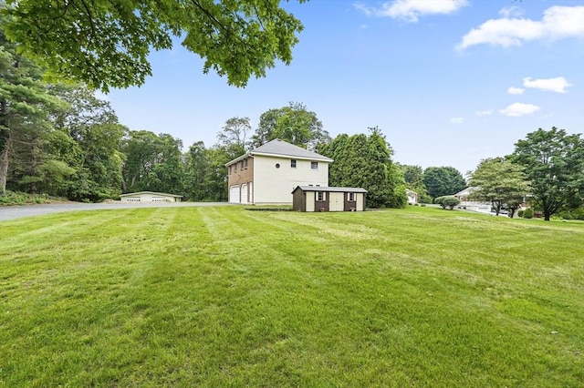 466 Hosmer St, Marlborough, MA 01752 - view of grassy yard with driveway, an attached garage, and a storage unit