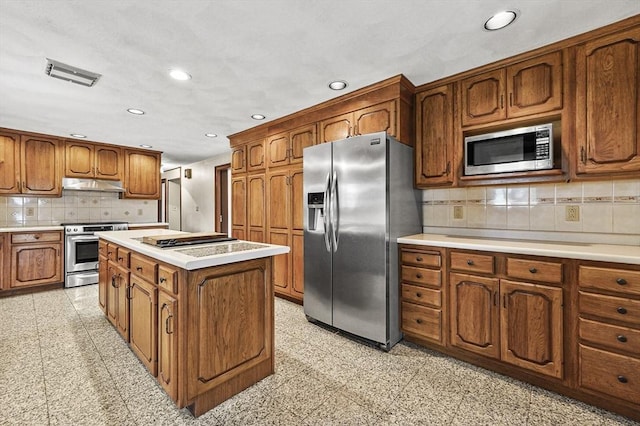 466 Hosmer St, Marlborough, MA 01752 - kitchen featuring appliances with stainless steel finishes, under cabinet range hood, recessed lighting, brown cabinets, and decorative backsplash