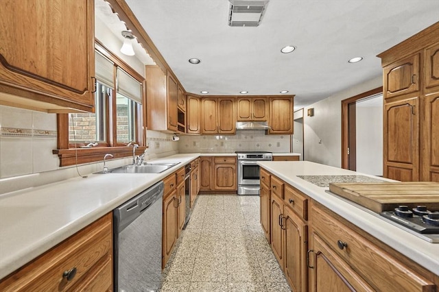 466 Hosmer St, Marlborough, MA 01752 - kitchen with stainless steel appliances, under cabinet range hood, recessed lighting, granite floors, and brown cabinets