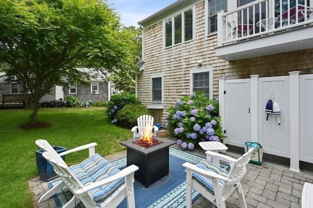 view of patio / terrace with a fire pit and a balcony