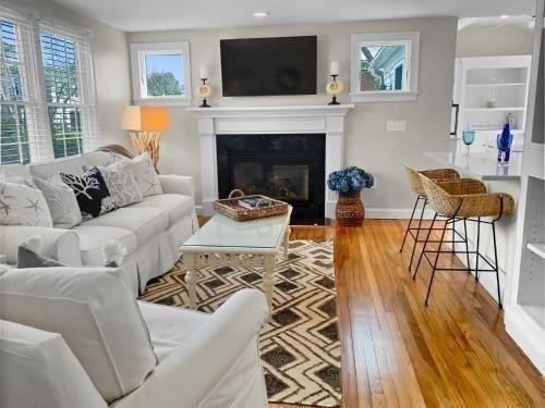 living area with a fireplace with flush hearth, baseboards, and wood finished floors