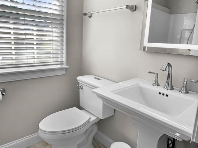 bathroom featuring a sink, toilet, and baseboards