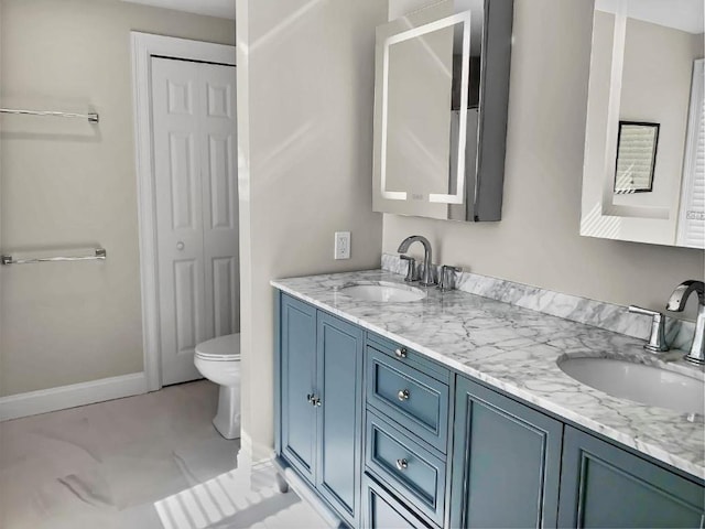 full bathroom featuring double vanity, a closet, a sink, and toilet