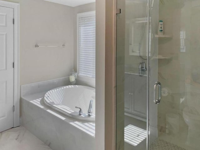 bathroom with marble finish floor, a stall shower, and a garden tub