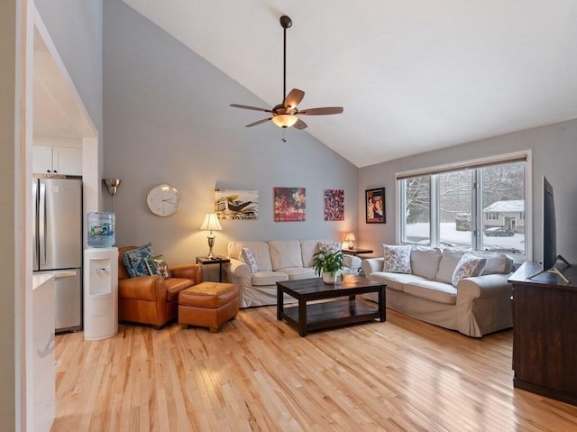 living room with ceiling fan, high vaulted ceiling, and light hardwood / wood-style flooring