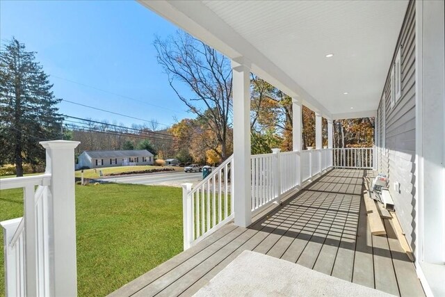 deck with covered porch and a lawn